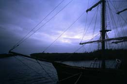 Segelboot vor Insel bei Sonnenuntergang